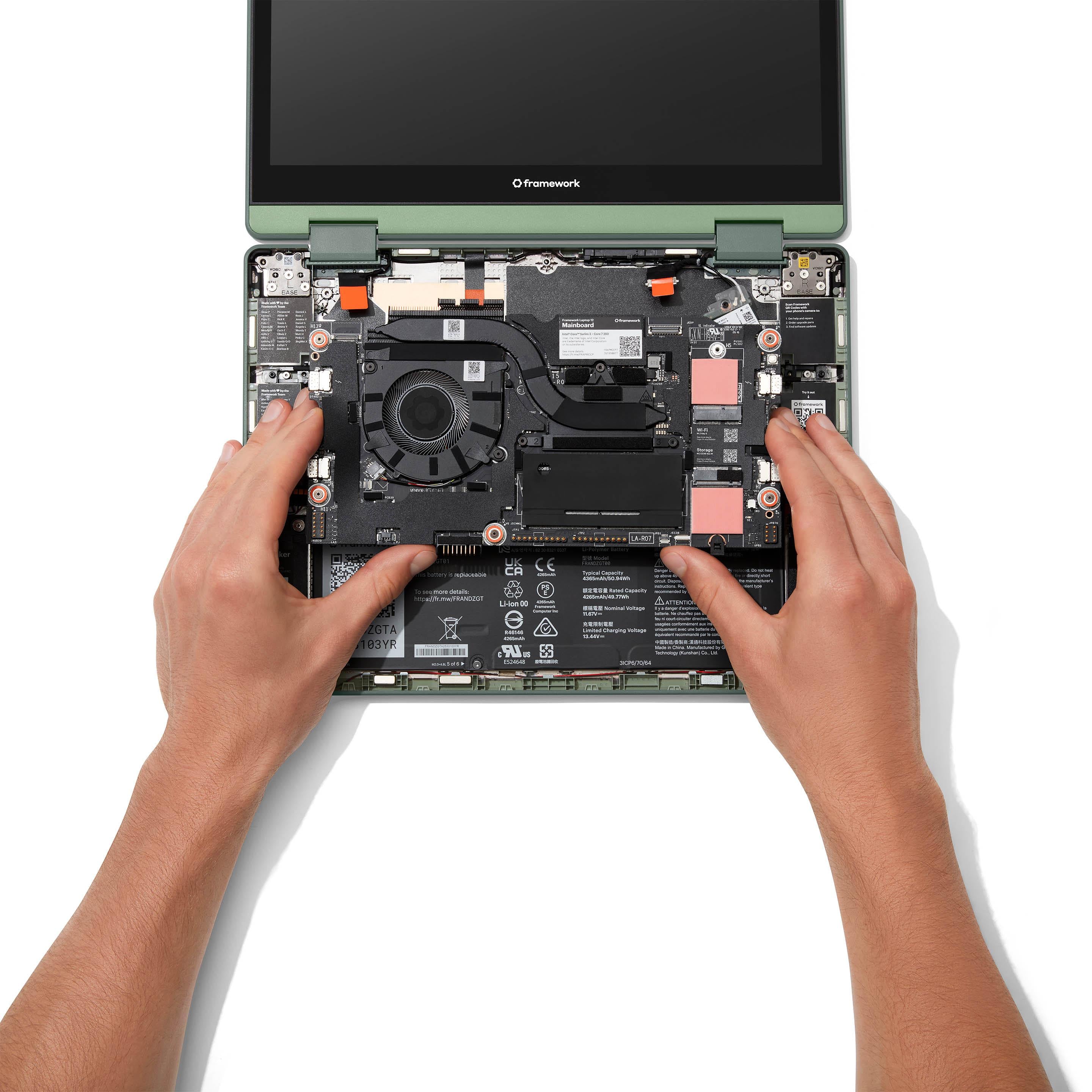 Image of hands installing a mainboard into a Framework Laptop 12